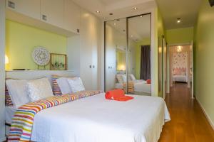 a bedroom with a large white bed with a mirror at Green Apartment in Funchal