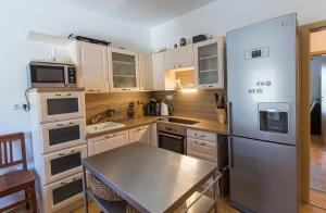 a kitchen with white cabinets and a stainless steel refrigerator at Lipno 35 - Lipno In in Lipno nad Vltavou