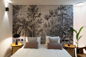 a bedroom with a large white bed with a wall mural at Fonte d'Oro Luxury Rooms in Rethymno Town