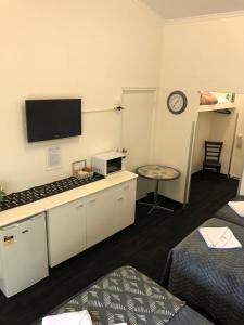 a room with a room with a bed and a tv at Blue Gums Hotel Motel in Teatree Gully