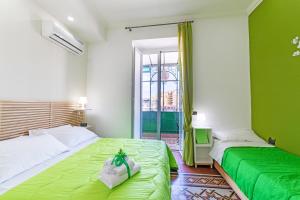 two beds in a room with green walls at Annunziata Bed and Breakfast in Naples