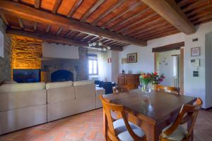 Una sala de estar con una mesa y una chimenea. en PODERE Piazza di Sopra, en Reggello