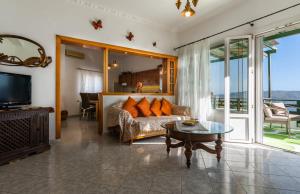 a living room with a couch and a table at Melisses Sea View House in Plaka Milou