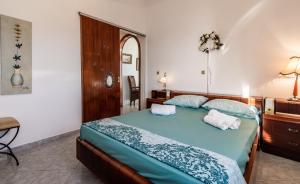 a bedroom with a bed with two towels on it at Melisses Sea View House in Plaka Milou