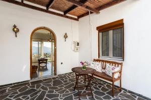 a room with a bench and a table and a mirror at Melisses Sea View House in Plaka Milou