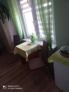 mesa y sillas en una habitación con ventana en Pokój w domku na mazurach ROGALE, en Stare Juchy