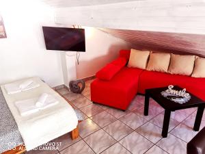 a living room with a red couch and a table at Albert Apartaments Krk in Krk