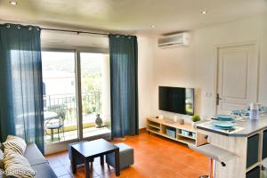 ein Wohnzimmer mit einem Sofa und einem TV in der Unterkunft Appartements MISTRETTA 33 Bouddha Zen 34 Arts Appart 44 NY City in Sainte-Maxime