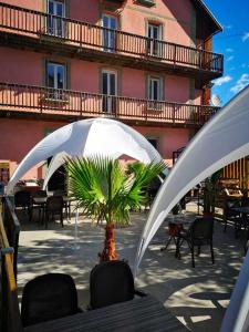 a table with a palm tree under a white umbrella at Icerock Hotel in LʼArgentière-la-Bessée