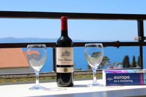 a bottle of wine and two glasses on a table at Apartments Slaven in Podgora