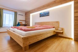 a bedroom with a wooden bed in a room at Camping & Pension Au an der Donau in Au an der Donau