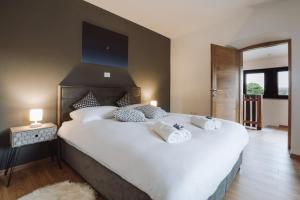 ein Schlafzimmer mit einem großen Bett mit weißer Bettwäsche und Kissen in der Unterkunft Apartma Ob stari murvi, Sežana in Sežana
