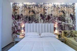 a bedroom with a large white bed and a couch at Hotel Stella D'Oro in Rimini