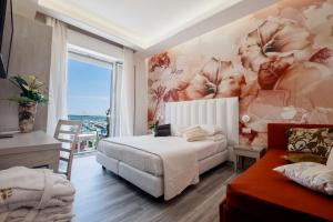 里米尼的住宿－斯特拉多羅酒店，一间卧室设有一张床和鲜花墙