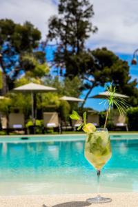 uma bebida sentada na areia junto a uma piscina em Leonardo Resort em Imperia