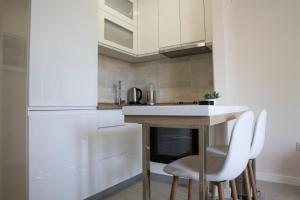 a kitchen with a table and two white chairs at Beach Front Apartment in Herceg-Novi