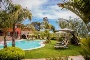 uma piscina com cadeiras e guarda-sóis num quintal em Leonardo Resort em Imperia