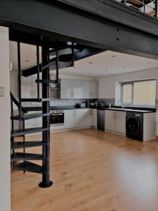 uma grande cozinha com uma escada em espiral num loft em The Studio em Farmborough