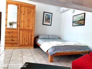 a bedroom with a bed and a wooden cabinet at Albert Apartaments Krk in Krk