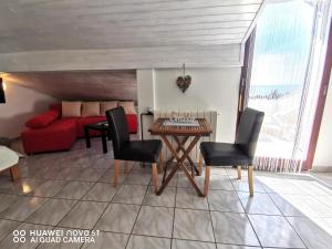 a living room with a table and a red couch at Albert Apartaments Krk in Krk