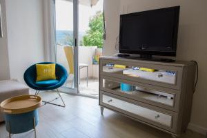 a living room with a tv on a dresser at Beach Front Apartment in Herceg-Novi