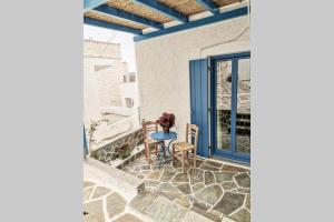 a patio with a blue door and a table and chairs at Kostos House BLUE in Kóstos