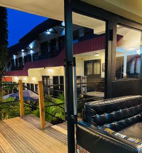 a house with a balcony with a couch on a deck at Détente Hôtel in Abidjan