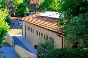 a building with a red tile roof and a yard at Camping Siena Colleverde in Siena
