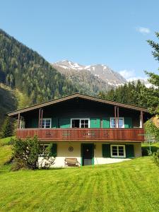 ein großes Haus mit einem Balkon auf einem Grasfeld in der Unterkunft Ferienhaus Erika in Mallnitz