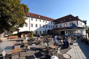 um pátio com cadeiras, mesas e edifícios em Kloster Frauenberg em Fulda
