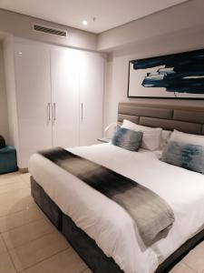 Un dormitorio con una cama grande y una pintura en Pearls of Umhlanga Apts, en Durban