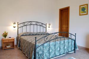 sypialnia z łóżkiem i drewnianymi drzwiami w obiekcie AGRITURISMO IL PINO - APPARTAMENTO QUERCE w mieście Gambassi Terme