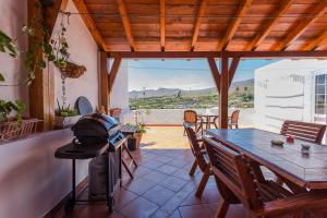 a patio with a table and chairs and a grill at MultiAventura en Agüimes in Agüimes