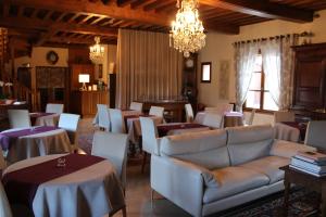 a living room with tables and a couch and chairs at Hotel Le Manasses in Curtil-Vergy