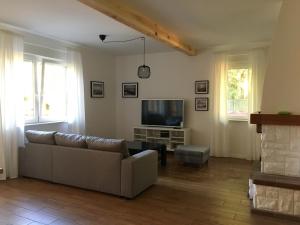 a living room with a couch and a television at Kopalnia Wspomnień in Kopalino