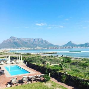 una piscina con vistas al océano y a las montañas en Cape Town Beachfront Apartments at Leisure Bay, en Ciudad del Cabo