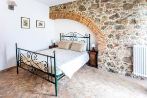 a bedroom with a bed in a stone wall at Podere Vecchia Commenda in Massa Marittima