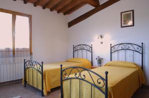 two beds in a room with a window at AGRITURISMO IL PINO - APPARTAMENTO CIPRESSO in Gambassi Terme