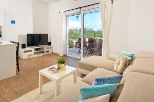 a living room with a couch and a tv at Sun Spalato Villa Cikas in Murter