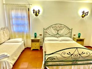 a bedroom with two beds and a window at Hotel Grazia Deledda in Arzachena