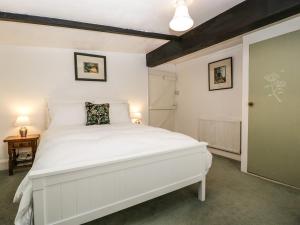 a bedroom with a white bed in a room at Small Piece in Minehead