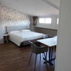 - une chambre avec un lit, une table et des chaises dans l'établissement La Mansarda Panoramica, à Vérone