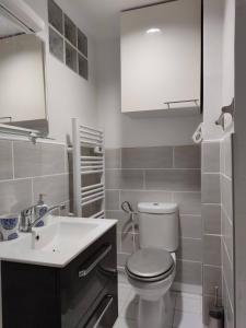 a white bathroom with a toilet and a sink at Modern 1 bedroom apartment near the metro. in Ivry-sur-Seine