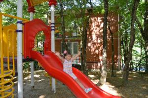 a little girl sliding down a slide at a playground at Villa Alla in Inal