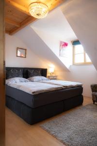 sypialnia z dużym łóżkiem na poddaszu w obiekcie Idyllische Designer-Apartments am Bio-Bauernhof in SalzburgerSeenland Schmiding 10 w mieście Seekirchen am Wallersee