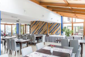 a dining room with tables and chairs and windows at Noce i Dnie in Postołowo