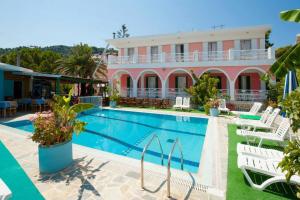 a hotel with a swimming pool in front of a building at Stella Studios in Argasi