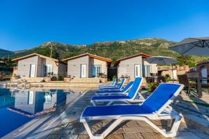 a row of blue lounge chairs next to a swimming pool at VILA LLANO in Vlorë