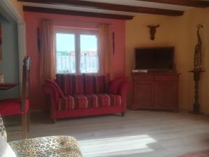 a living room with a red couch and a television at Ferienhaus Safari in Sasbach am Kaiserstuhl