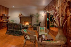 a living room with a table and chairs and a fireplace at Maekok River Village Resort in Mae Ai